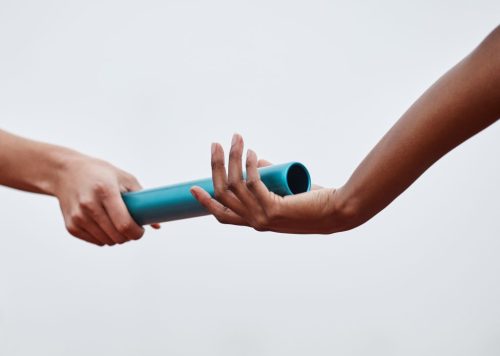 Nothing will stop us now. Shot of two athletes passing a baton d